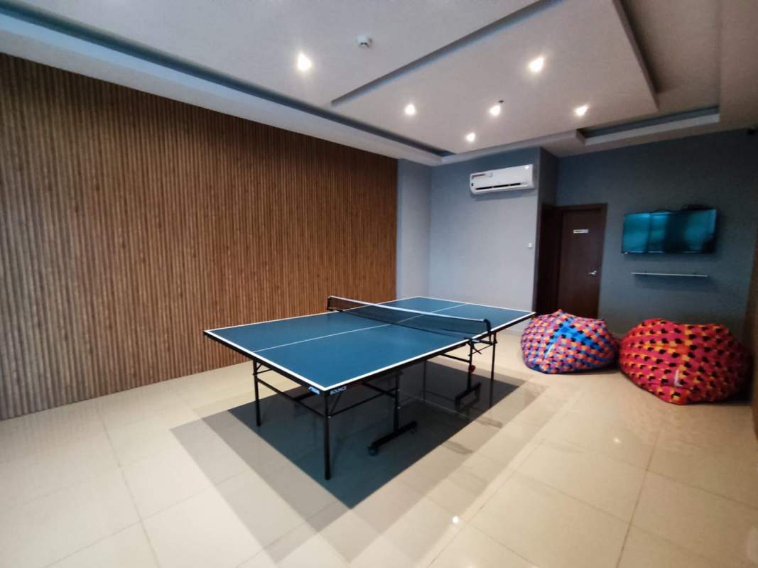 Indoor game room with ping pong table and TVs in PH Carrasquilla Park