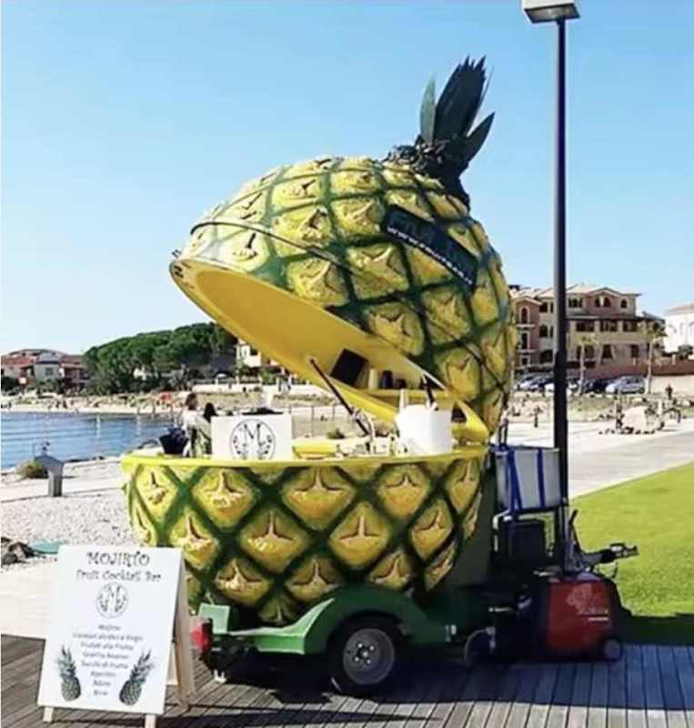 Orange fruit-shaped portable juice kiosk at beachfront commercial area in Panama