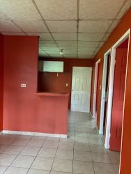 Interior with kitchen open pass-through window red walls in La Pradera La Chorrera Panama