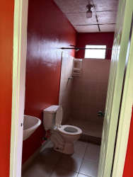 Simple bathroom red walls toilet sink shower La Pradera La Chorrera Panama