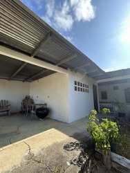 Spacious bedroom with tiled floor, ceiling fan, and large wooden wardrobe
