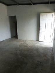 Empty room with concrete floor and white walls at affordable apartment La Espiga Panama