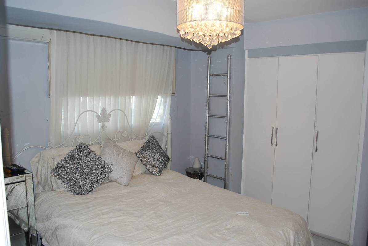 Elegant bedroom with built-in wardrobe, chandelier, metallic bed frame in PH Coco del Mar