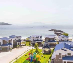 Aerial coastal view of beachfront residential houses blue roofs playground near Playa Dorada sandy beach