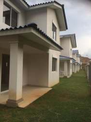 Two-story modern houses with tiled roofs, covered patio, lawn areas in Playa Dorada Playamar Panama