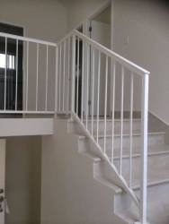 Open interior staircase with white railing light gray walls leading to bedrooms in Playamar Playa Dorada Panama