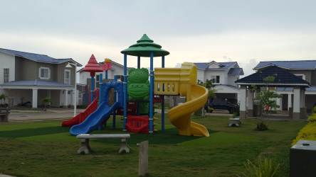 Colorful playground slide swing set green lawn inside Playamar Playa Dorada Vacamonte Panama