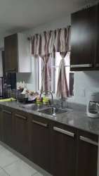 Contemporary kitchen with granite countertops, double sink, window dark cabinets in Playamar Panama