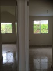 Two adjacent empty bedrooms tiled floors large windows natural light Playamar Playa Dorada Panama