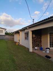 Large backyard with grass lawn, covered terrace in Quintas del Pacífico house La Chorrera Panama