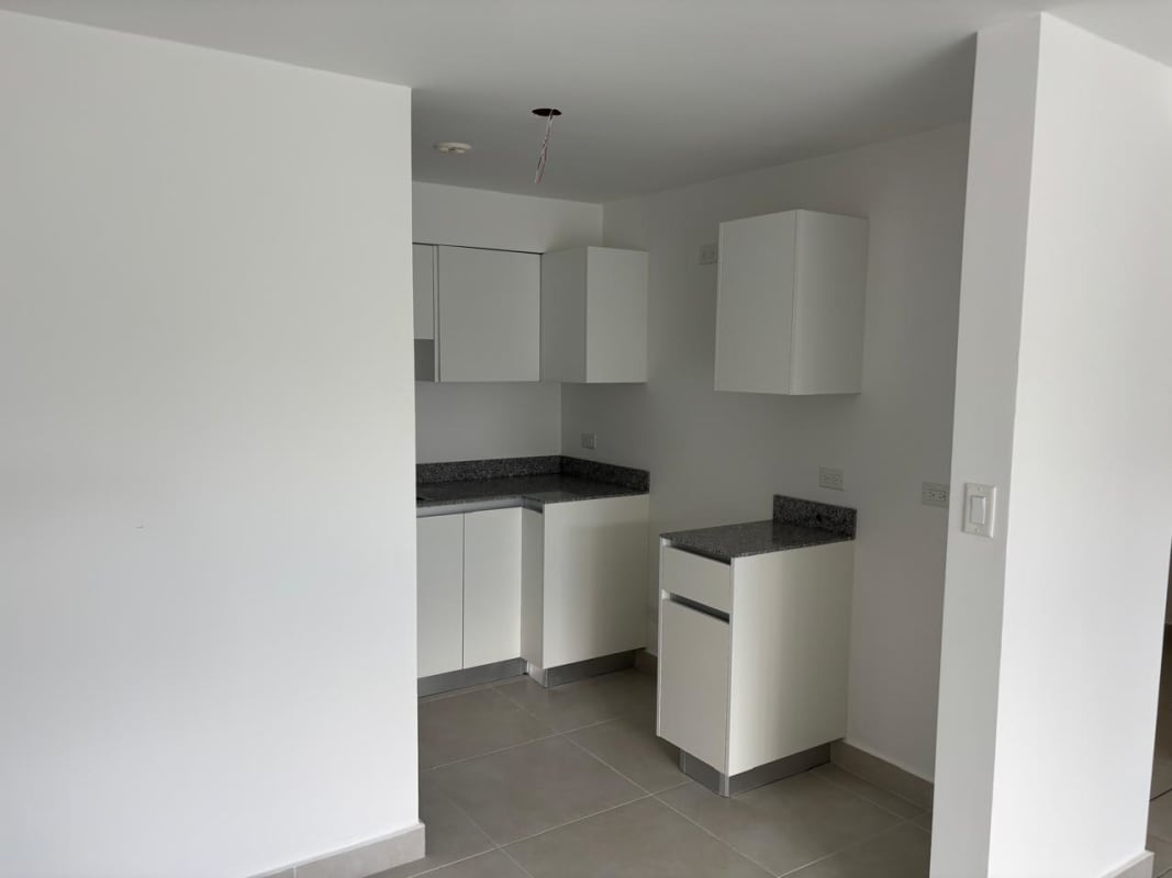 Contemporary kitchen with granite countertops and white cabinets PH Panama Viejo Residences