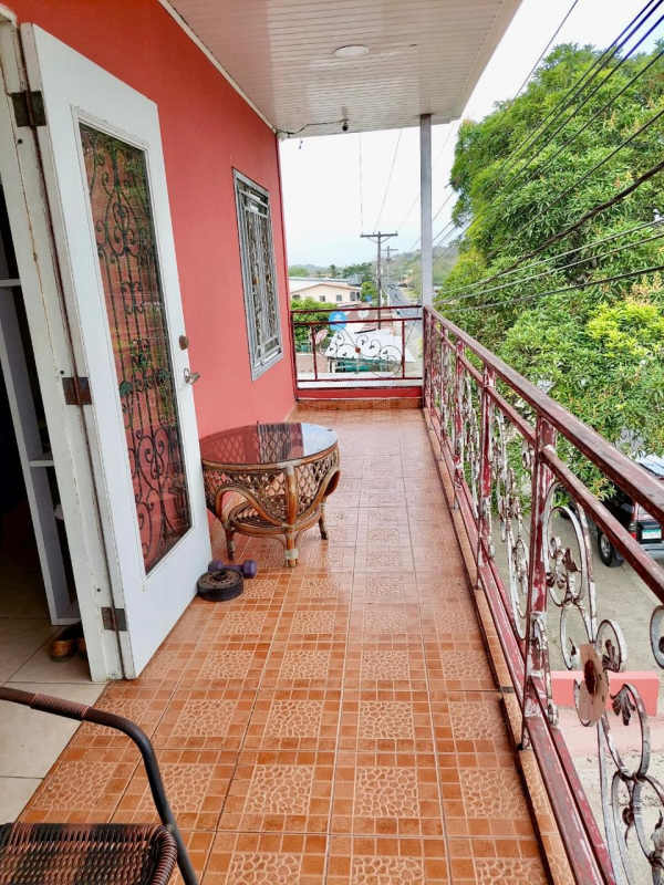 Red two-story building with corner location garage doors balconies Panama Canita