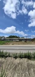 Fenced vacant land with paved road access under blue sky in El Espino La Chorrera Panama