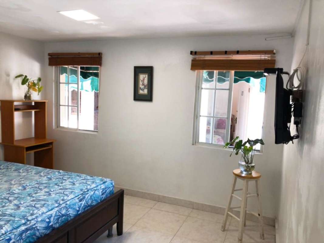 Tropical patio with umbrella, metal seating, and grill area PH El Carmen Suites El Carmen Panama