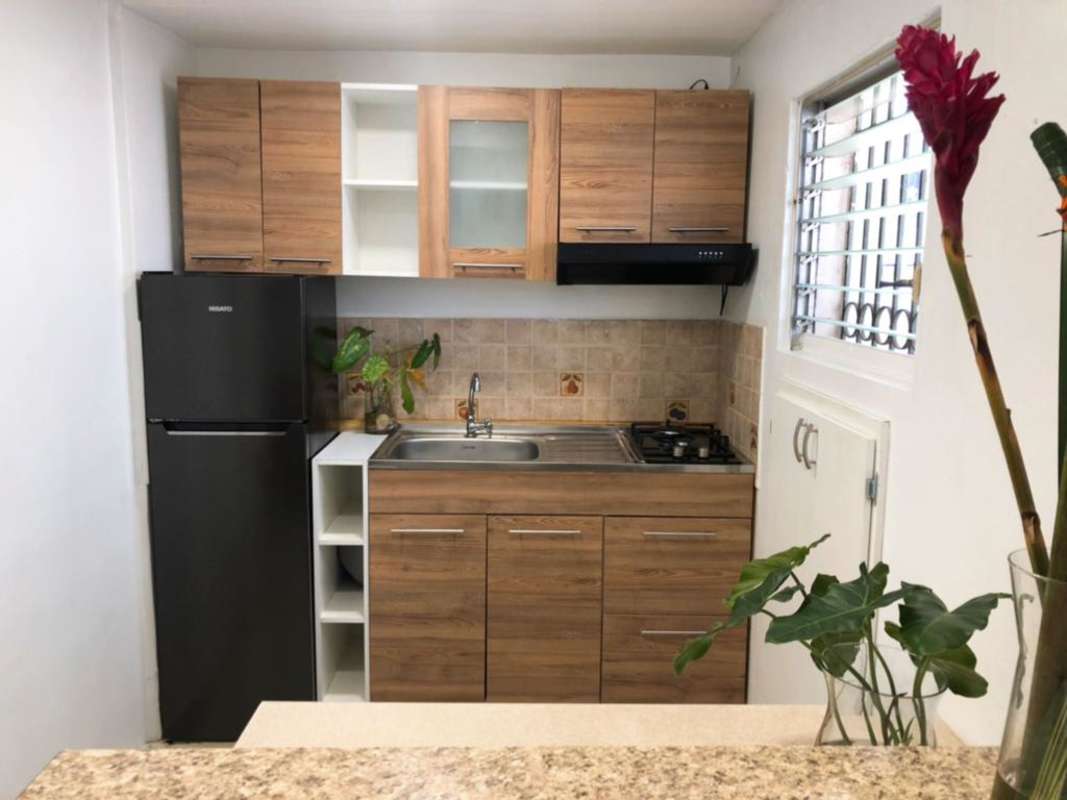 Modern kitchenette with appliances granite counter and wood cabinetry PH El Carmen Panama