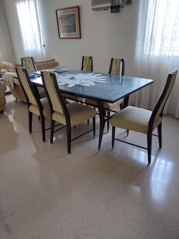 Dining area with glass table upholstered chairs and AC in Villa de las Fuentes Panama