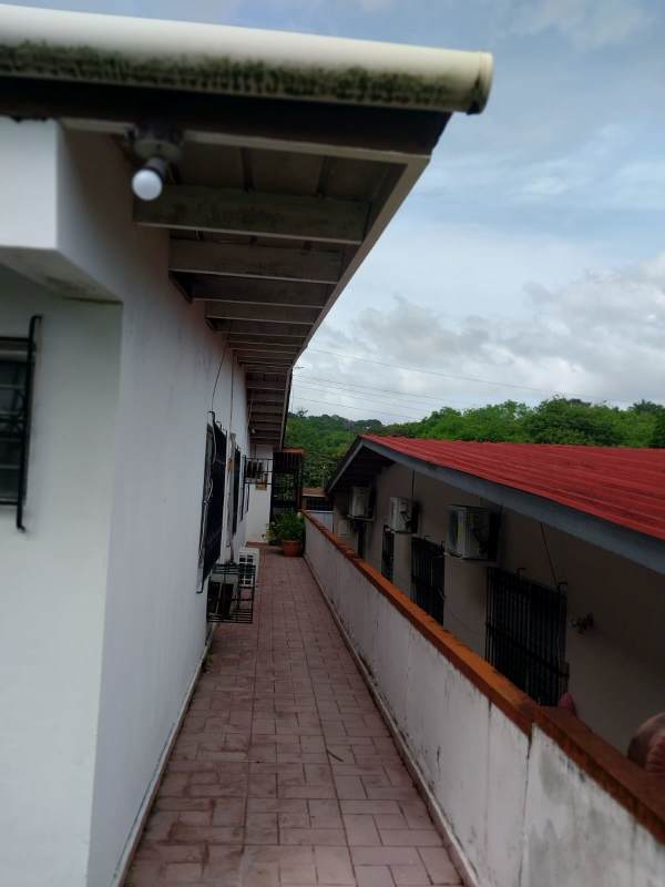 Covered exterior walkway with plants and security bars Villa de las Fuentes Panama