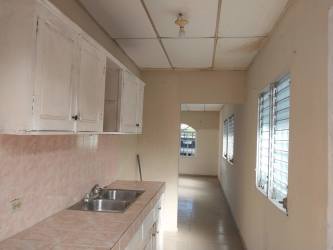 Basic functional kitchen with tiled counter and sink in affordable home Chitré Panama