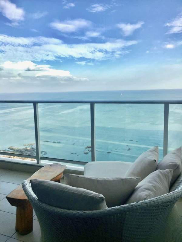 Stylish furnished living room with ocean view balcony access in PH Dupont Panama City