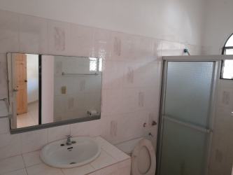 Bright tiled bathroom with glass shower, mirror, sink in duplex for rent Chitré Panama