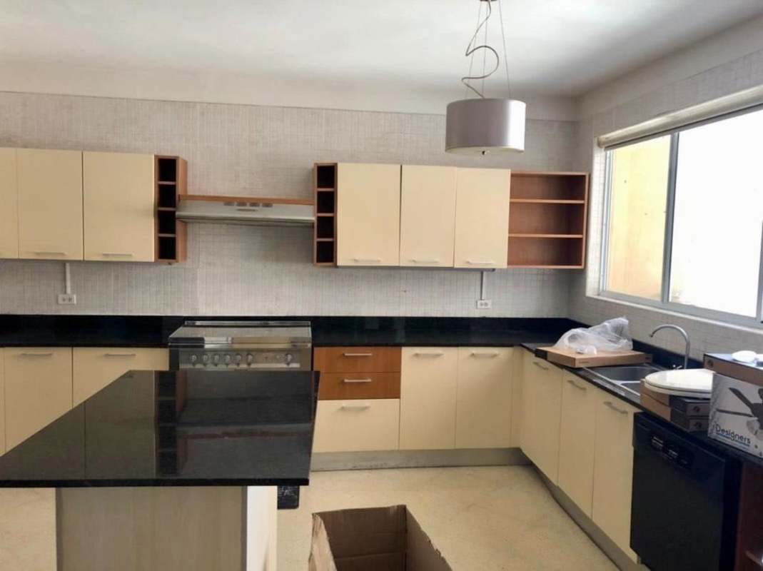 Modern kitchen with island, black countertops, large window in PH Vistanova El Cangrejo Panama