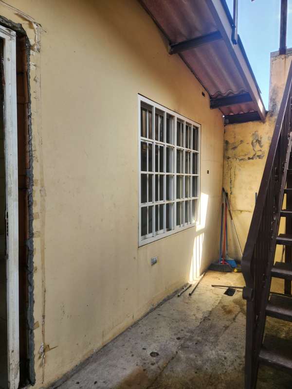 Exterior corridor with metal stairs large grid window cement floor Brisas del Golf house for sale