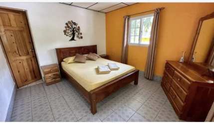 Rustic open-air dining area with large ocean-themed mural in eco-hostel Portobelo