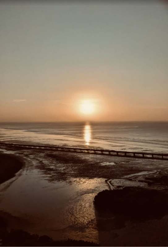 Sunset over Pacific Ocean with pier and calm waters from Coco del Mar Panama