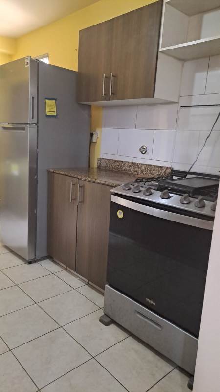 Kitchen with granite countertops, wooden cabinets, refrigerator and stove PH Mallorca Park Garden Los Andes