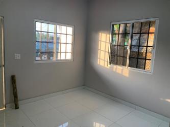 Empty interior space with large windows, tiled floor, and natural light in commercial space La Arena Chitré