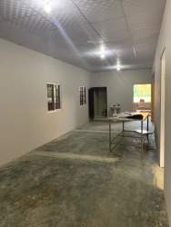 Multipurpose open room with drop ceiling, concrete floor, and fluorescent lighting in commercial building Chitré Panama