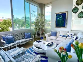 Sunroom with large windows, garden views, coastal decor at Punta Barco Village