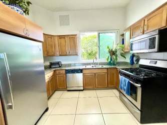 Contemporary kitchen with granite countertops, window and appliances at Punta Barco Village Panama