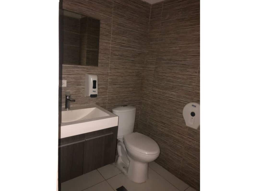 Modern commercial bathroom with wall-mounted sink, toilet, white tiles in PH Obarrio Business Center Obarrio Panama
