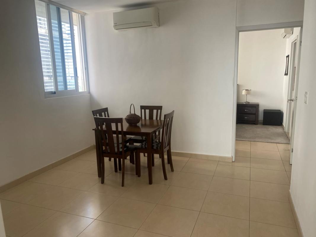 Minimalist dining area with wooden table, large windows and city views in PH BICSA Panama