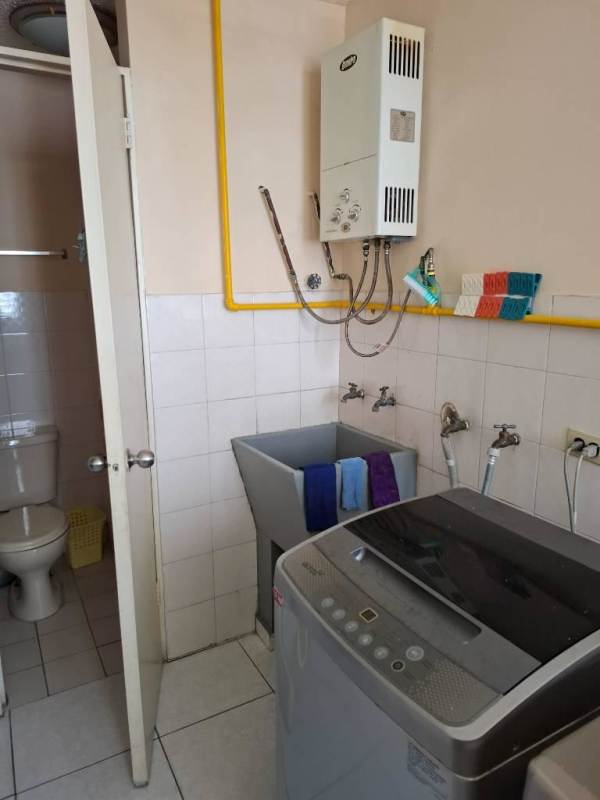 Living area with red sofa, white tiles, glass doors to balcony in PH Vista Hermosa Panama City