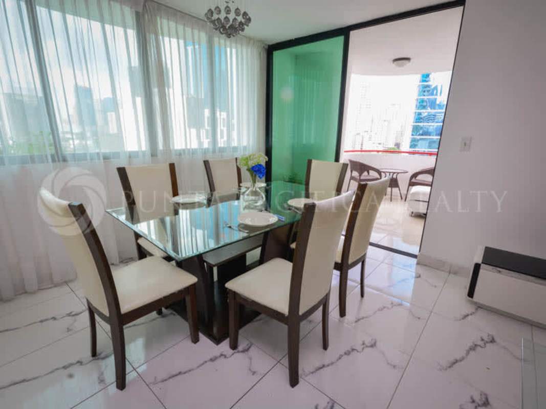 Modern dining area with marble floor and balcony facing Panama City at PH Torre Cosmos Calle 50