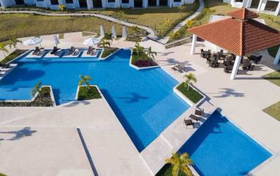 Resort-style swimming pools with sundeck umbrellas and gazebo at Playa del Sol San Carlos Panama