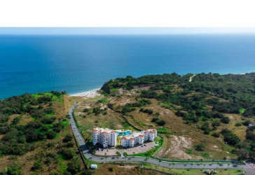 Aerial view of beachfront apartment buildings surrounded by greenery at Playa del Sol San Carlos Panama