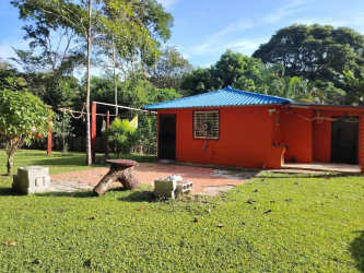 Paved country driveway surrounded by trees leading into ranch property in Las Ollas Arriba Panama