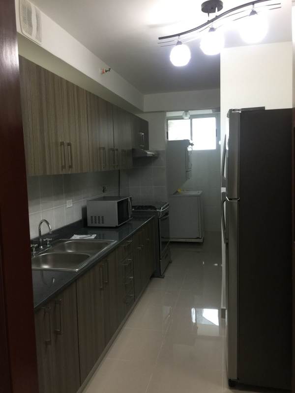 Galley kitchen with granite countertop, stainless appliances, tile backsplash, PH Residencias del Sol Panama