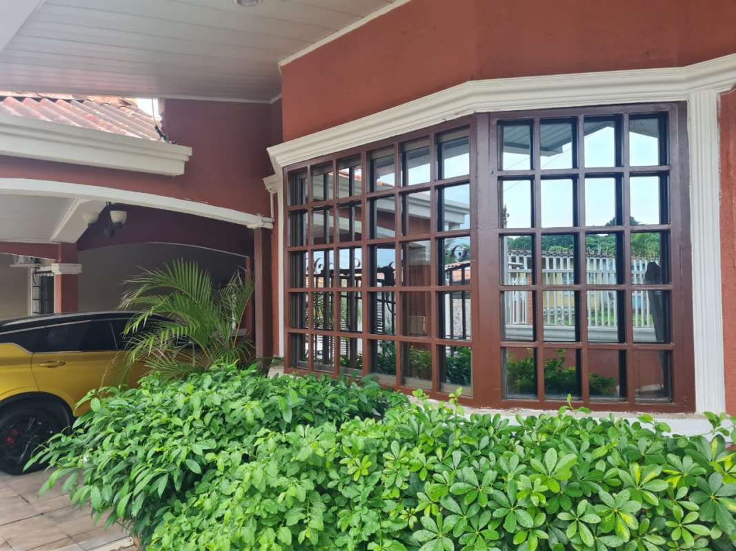Traditional facade with bay window, garden bushes and covered carport Praderas San Antonio Panama