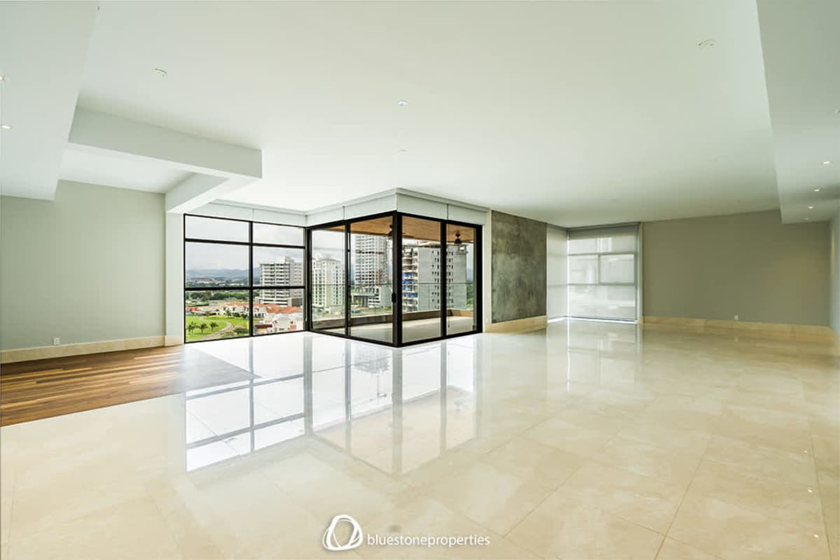 Open-plan living dining area with full-height windows and balcony panoramic golf course views at Santa Maria Panama