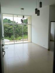 Living and dining area with large window and balcony access in PH Natura Costa Verde Panama