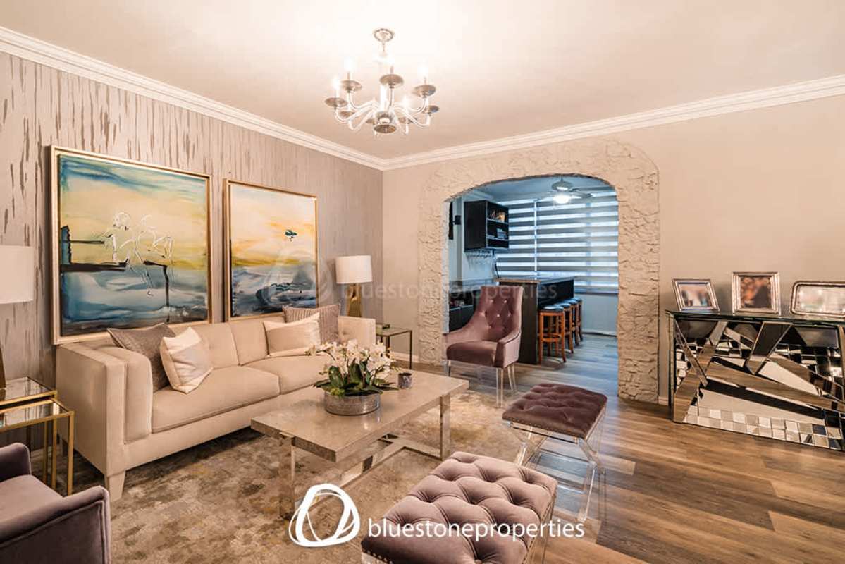 Modern dining and living space with chandeliers and archway in Marbella apartment