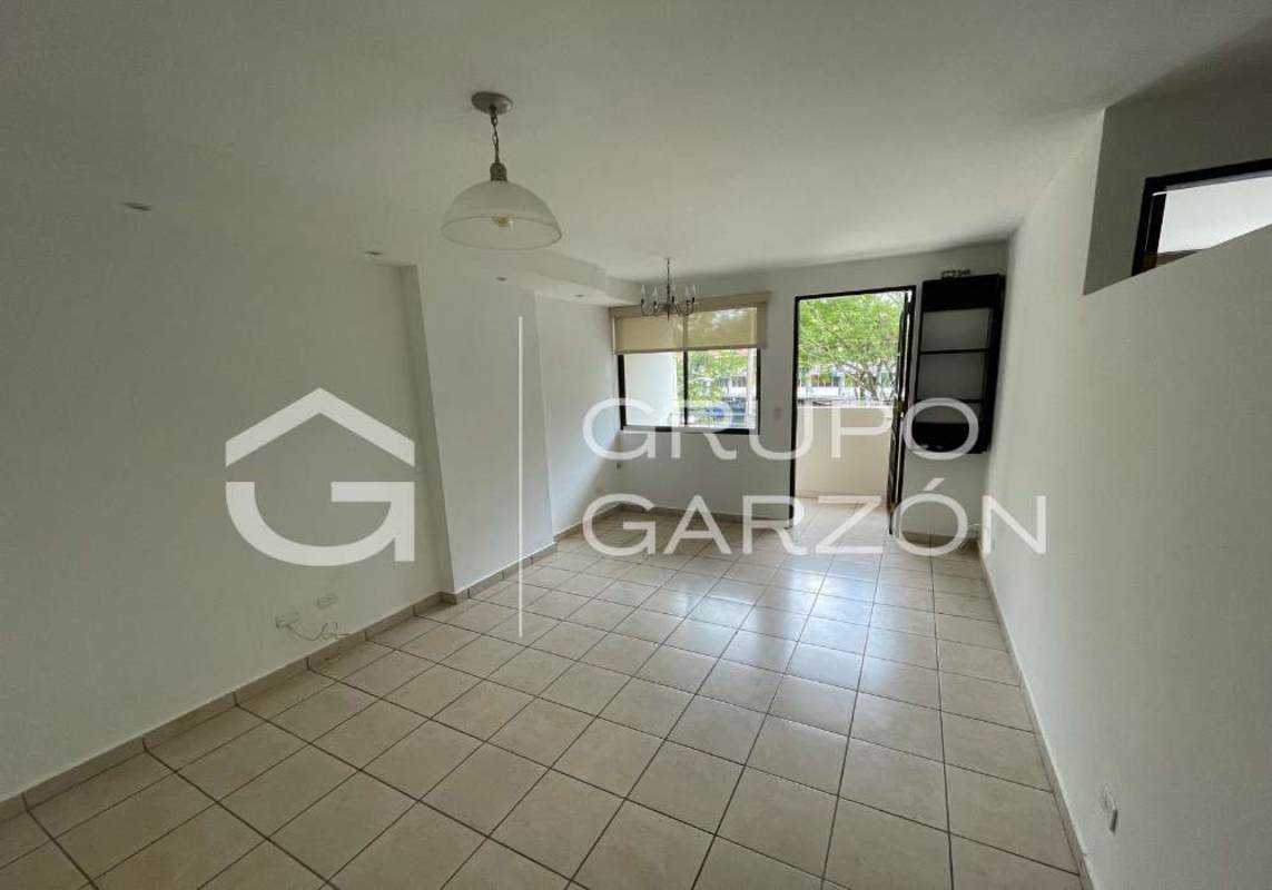 Living room area with ceramic tile floor and large window with roller blind in PH Altos de la Colina apartment rental