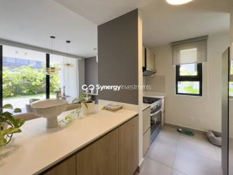 Modern bathroom featuring large wall mirror, window, and sleek vanity