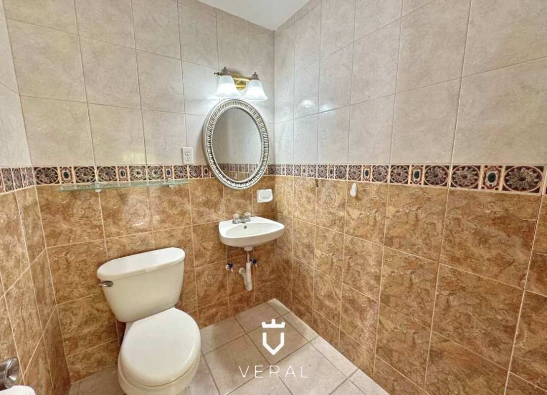 Spacious kitchen with cream cabinets, granite countertops, stainless steel refrigerator in Cardenas Village Panama