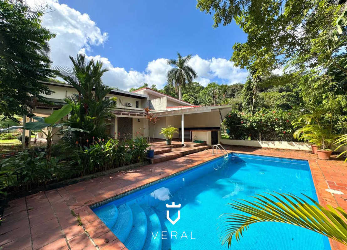 Private pool with barbecue and bar area surrounded by lush garden in Cardenas Village Ancón Panama