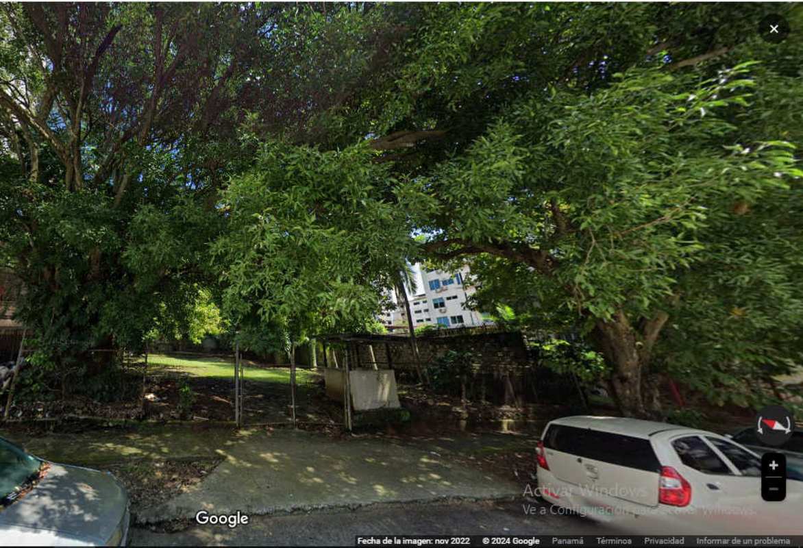 Empty lot with fence and mature trees in central El Cangrejo neighborhood Panama City